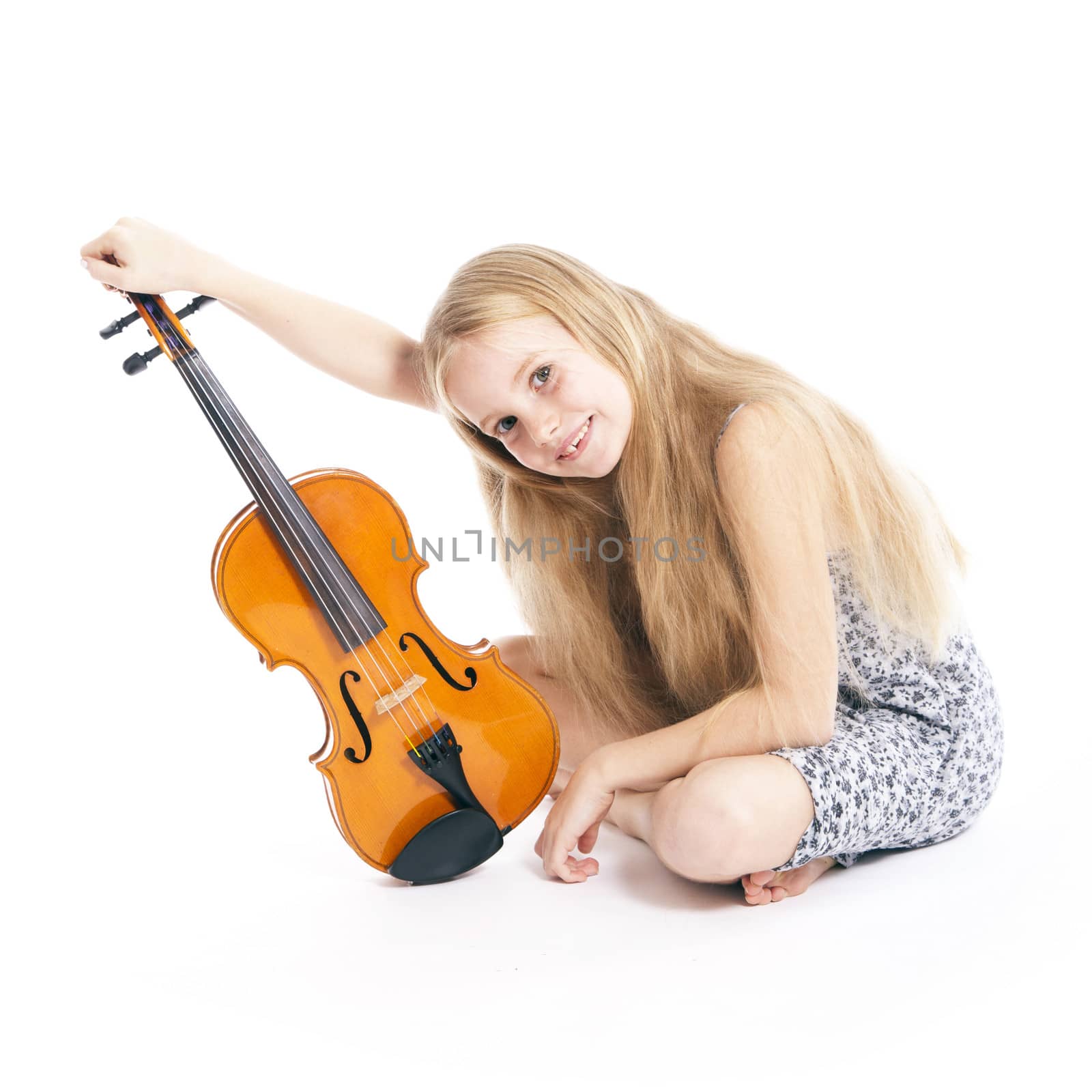 young girl in dress happy with violin in studio against white background