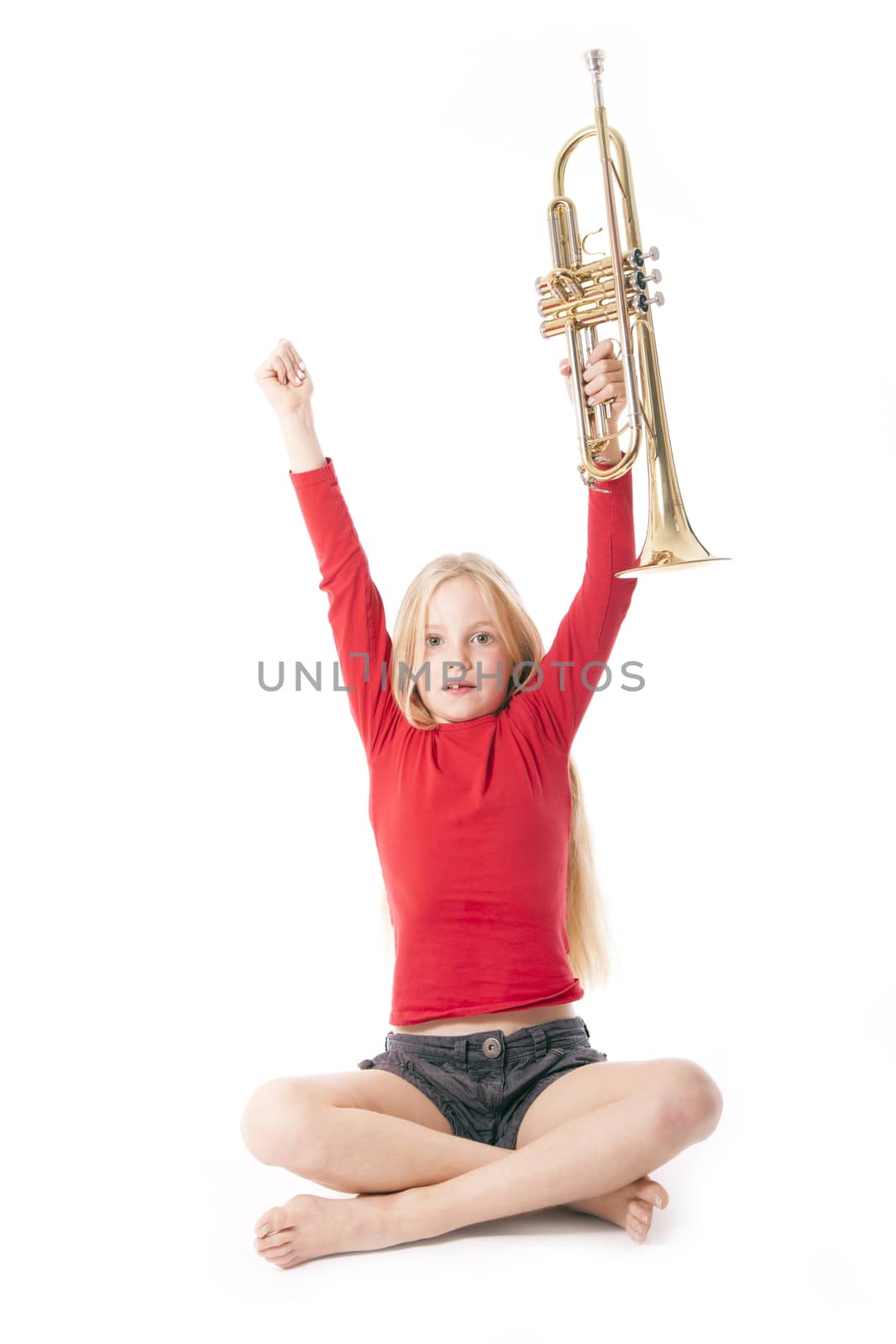 young girl in red holding trumpet in the air against white backgound