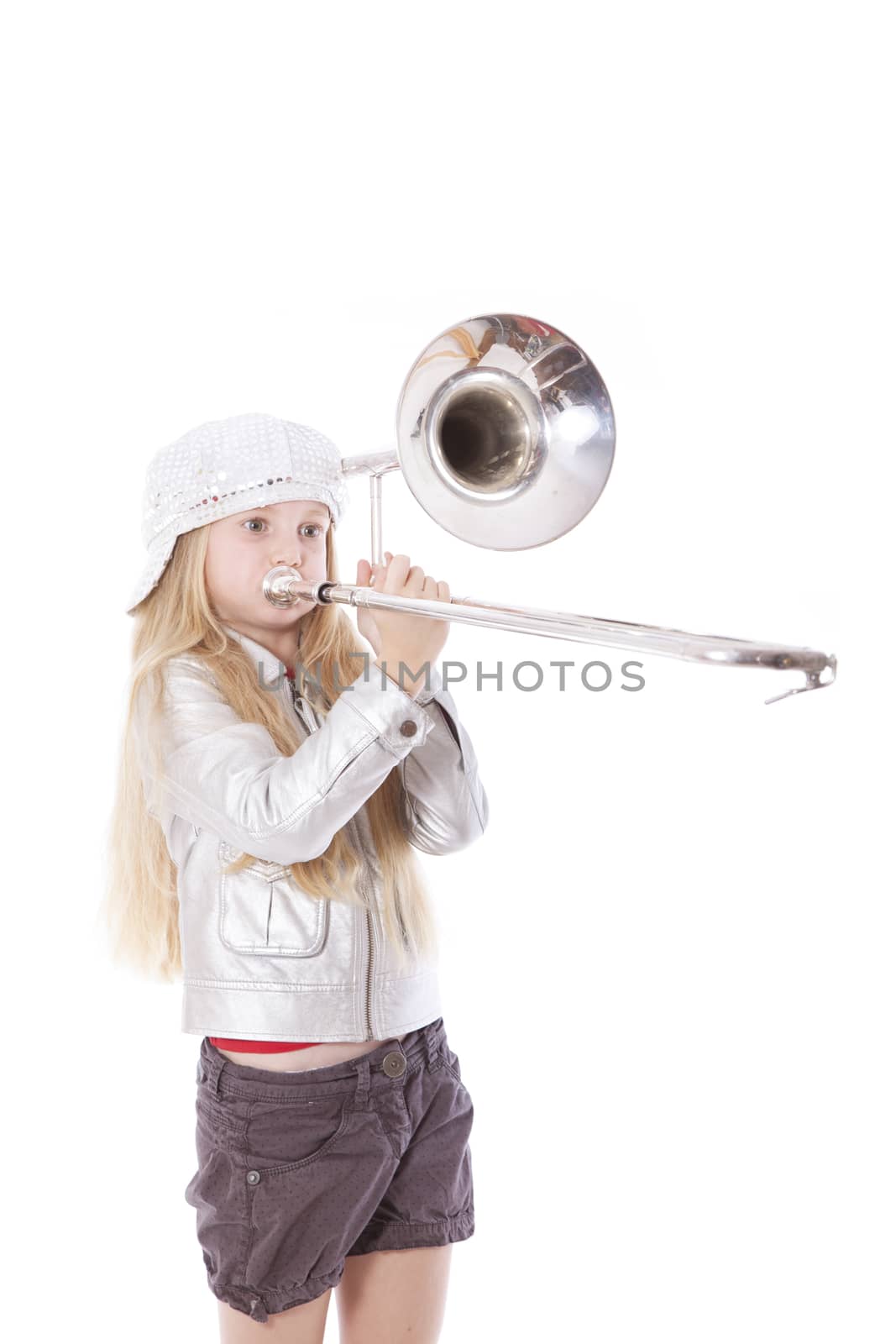 young girl playing trombone in studio against white background