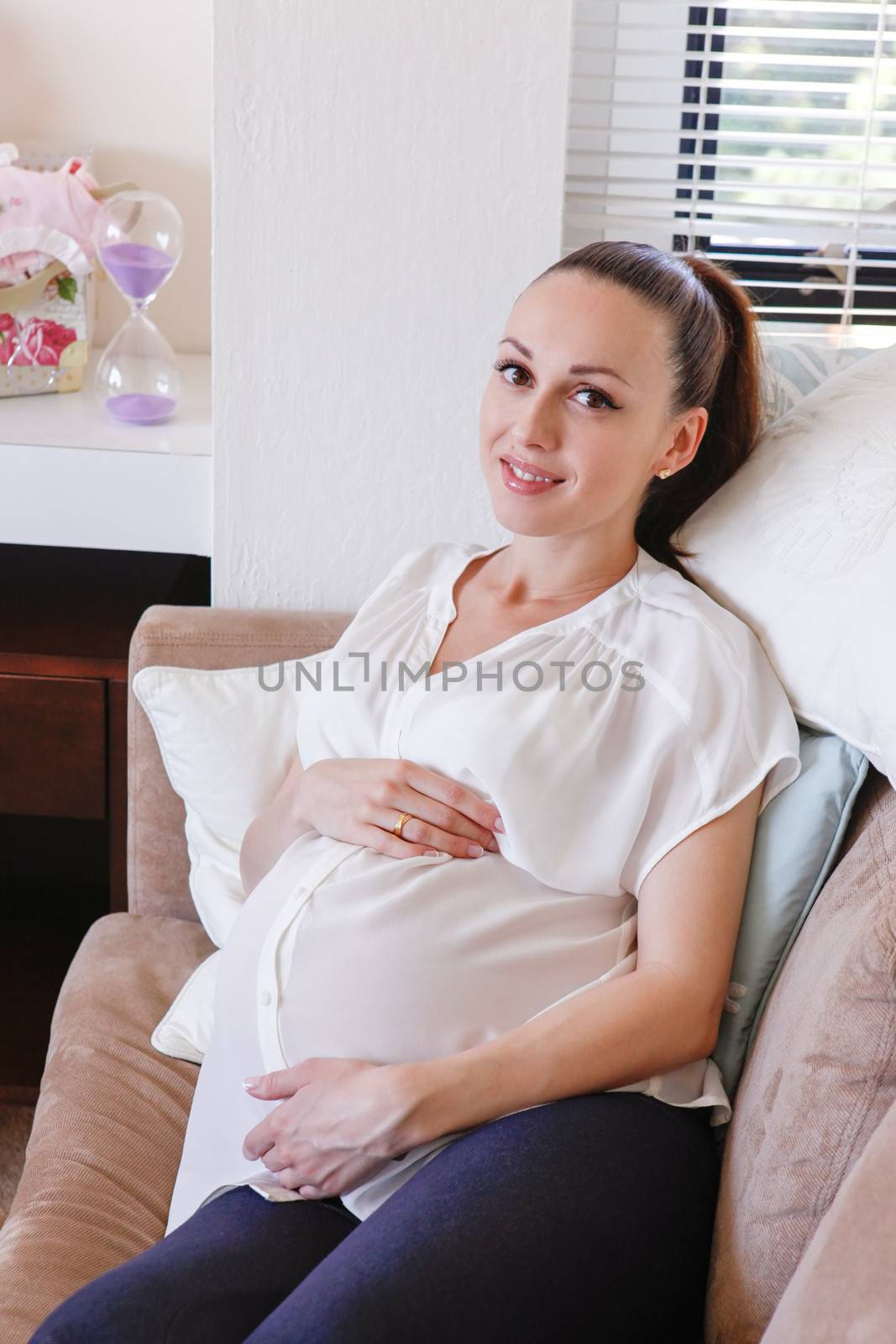 Beautiful young pregnant woman lying on the sofa