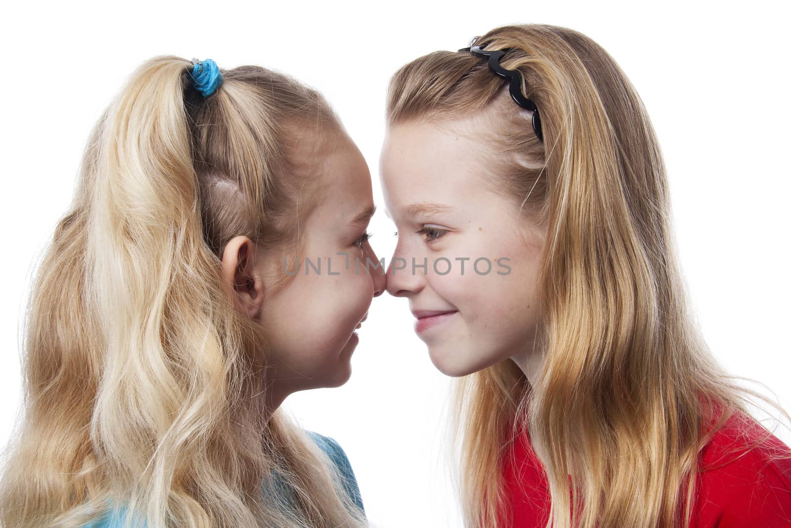 Two sisters nose to nose over white background