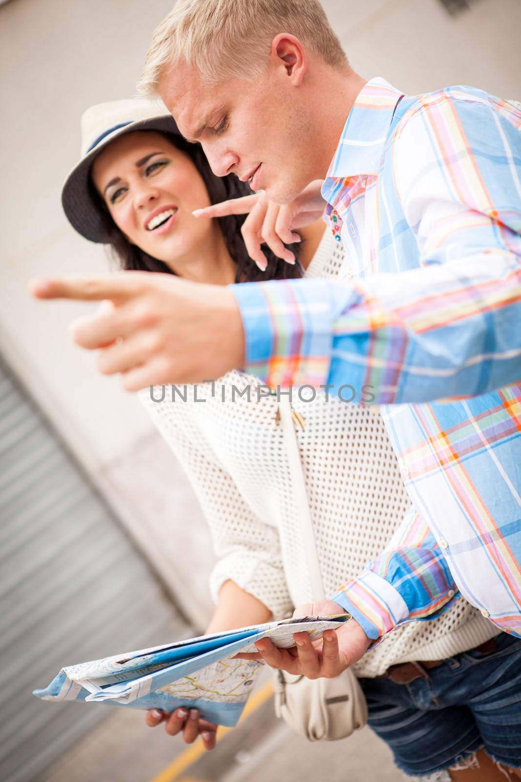 young attractive tourist couple with city map in summer outdoor sightseeing
