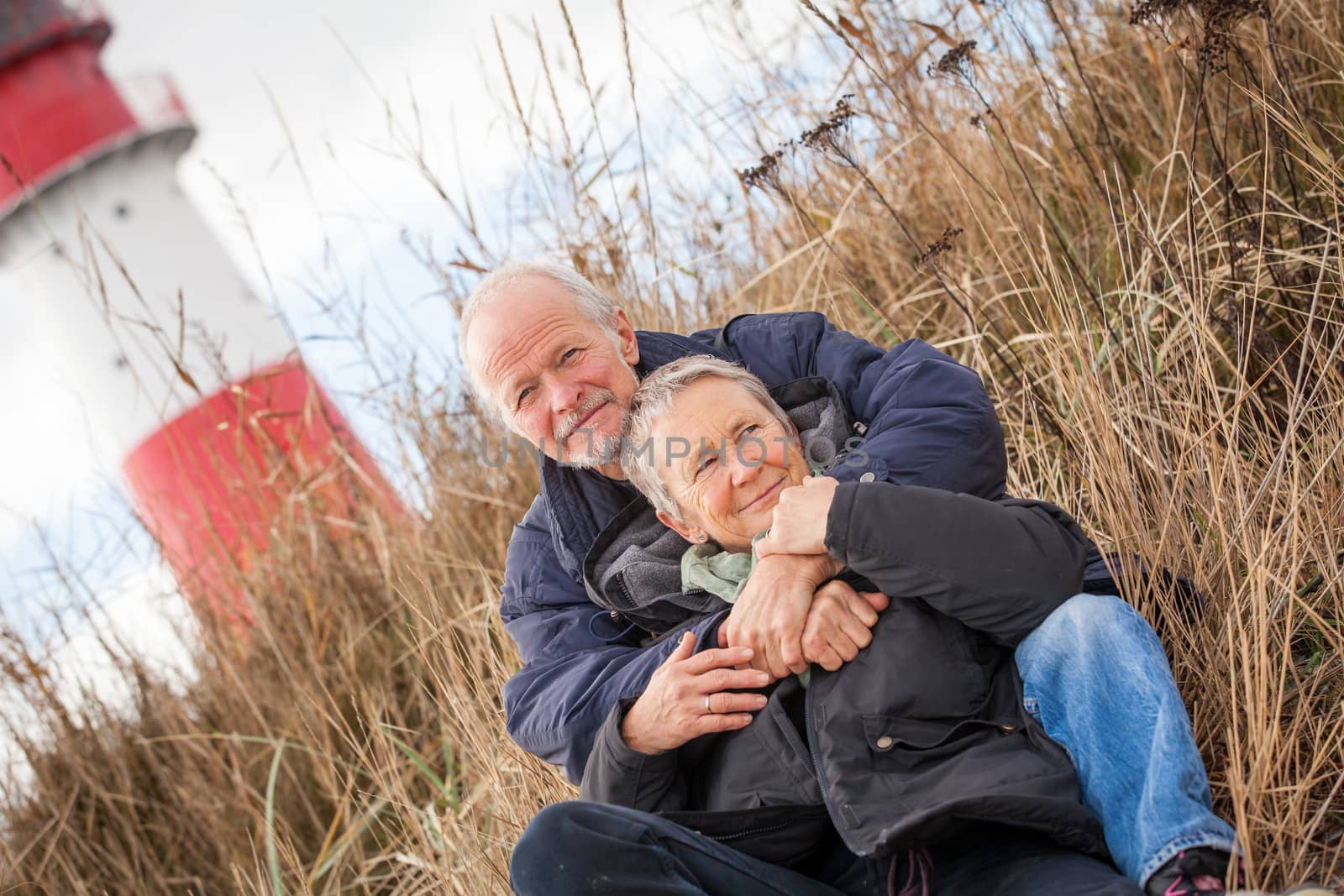 happy mature couple relaxing baltic sea dunes in autumn