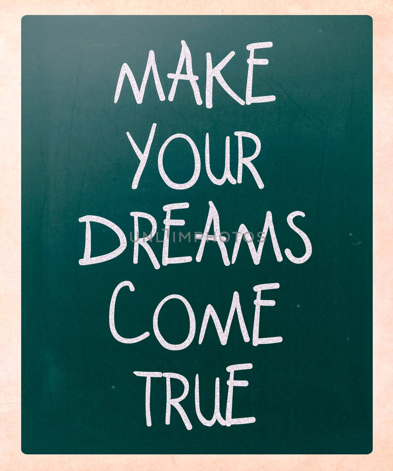 "Make your dreams come true" handwritten with white chalk on a blackboard