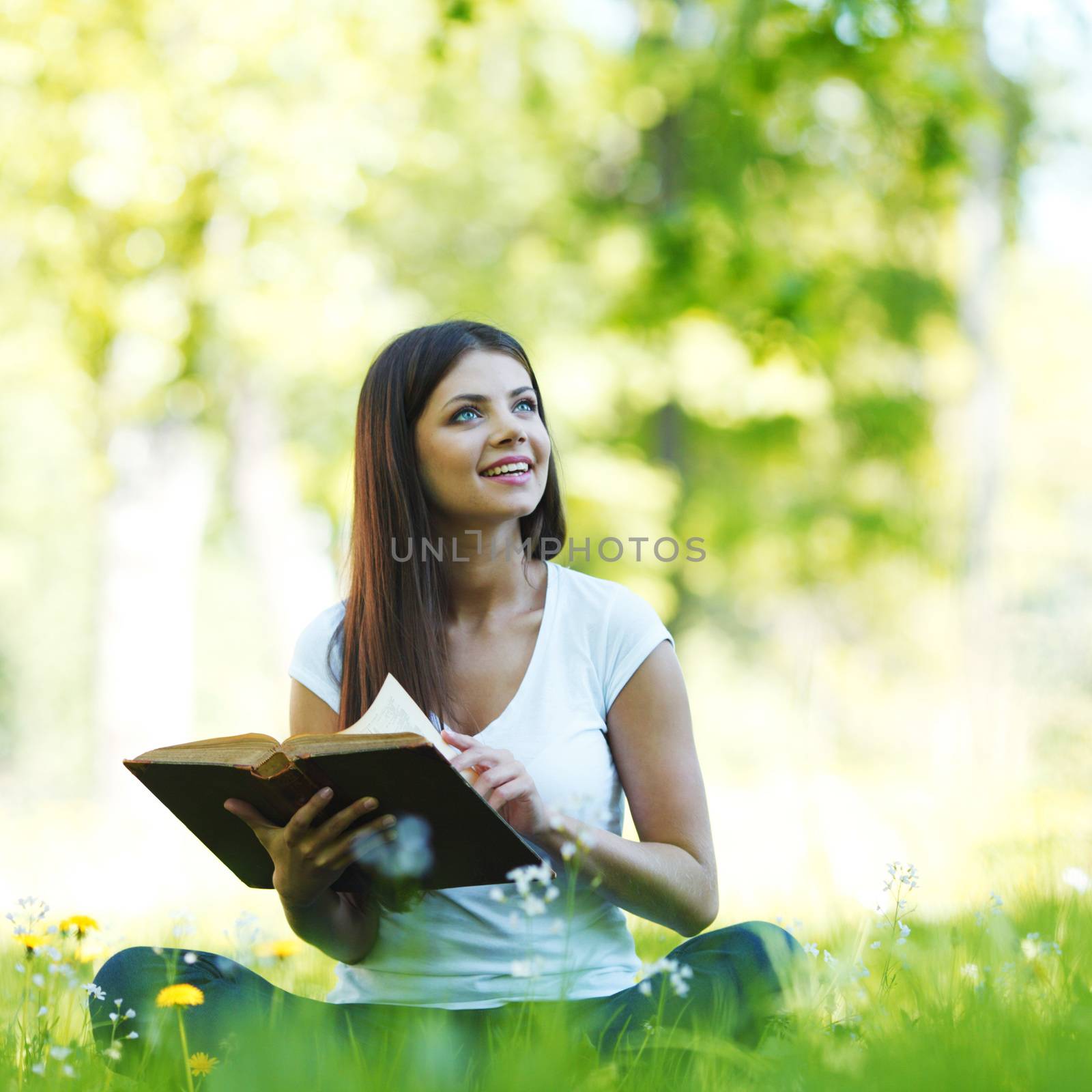 Woman reading book outdoors by Yellowj