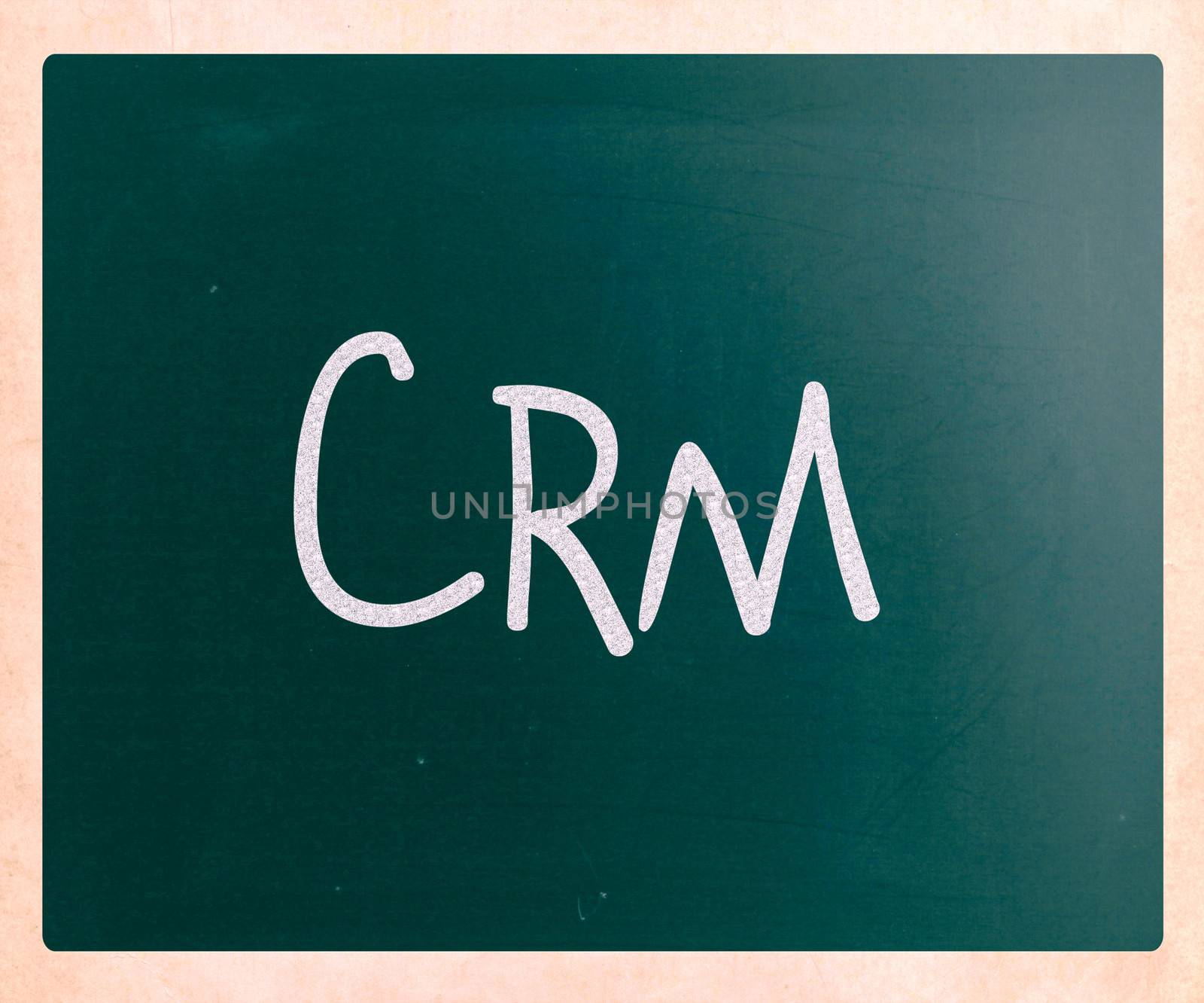 The word "CRM" handwritten with white chalk on a blackboard