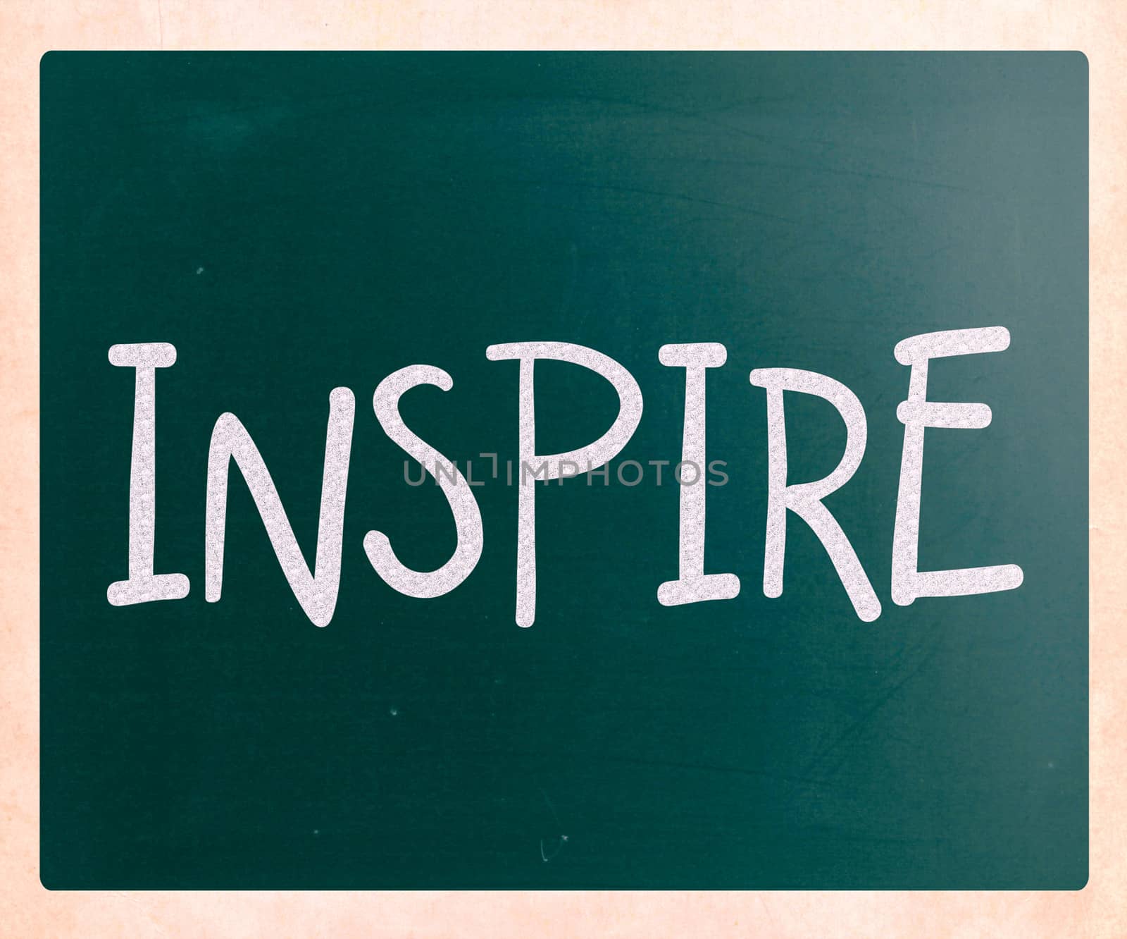 "Inspire" handwritten with white chalk on a blackboard