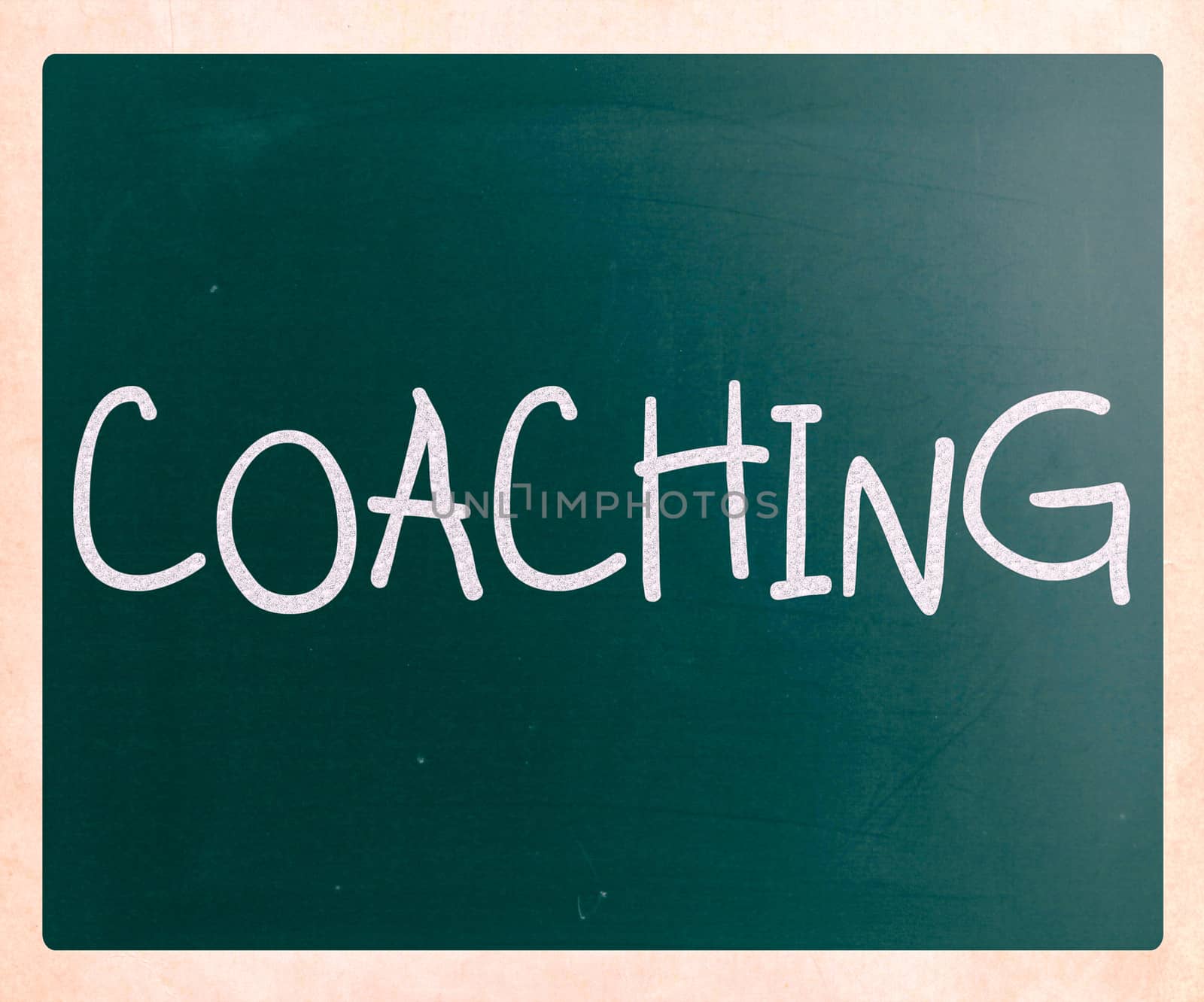 "Coaching" handwritten with white chalk on a blackboard