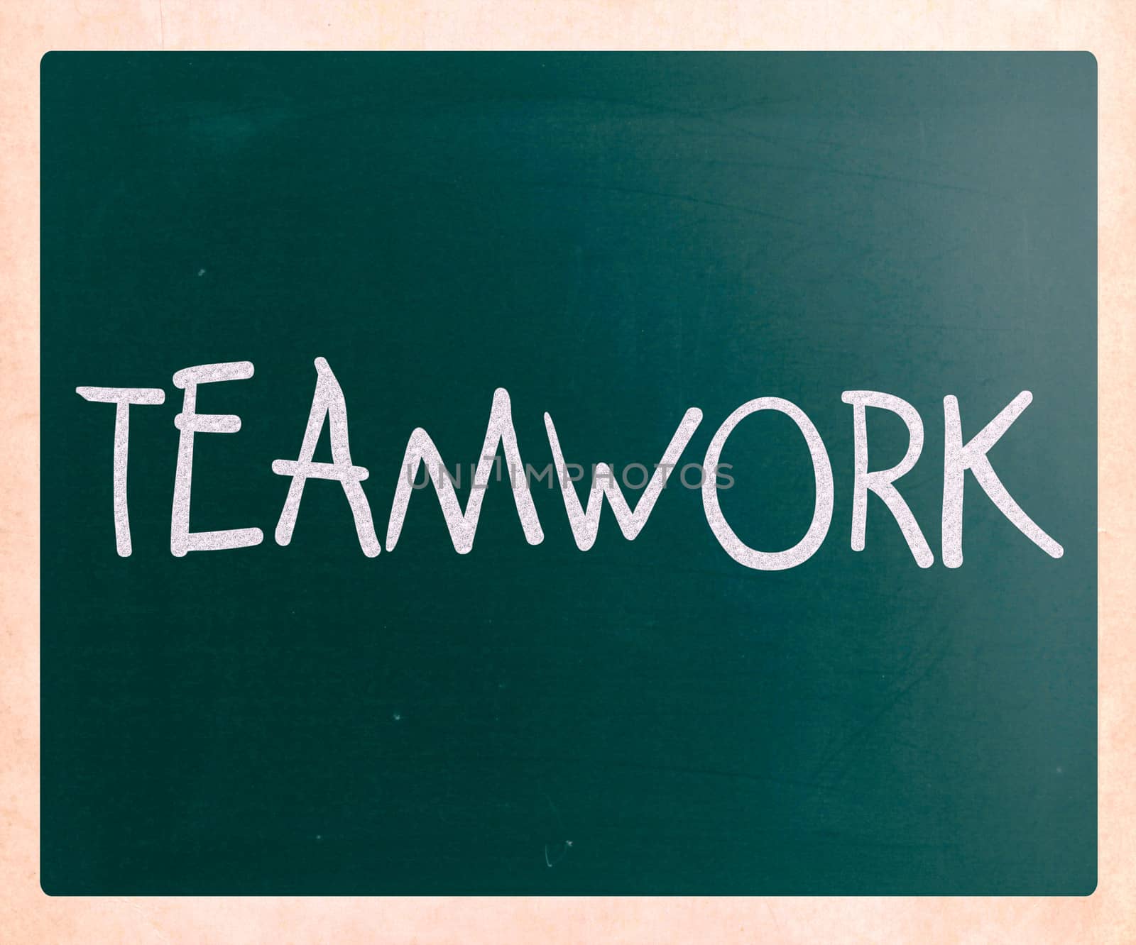 The word "Teamwork" handwritten with white chalk on a blackboard