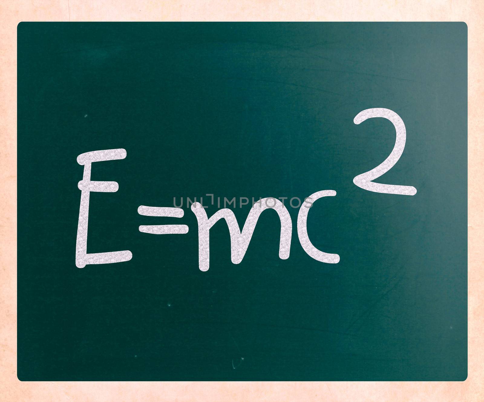 E=mc2 handwritten with white chalk on a blackboard