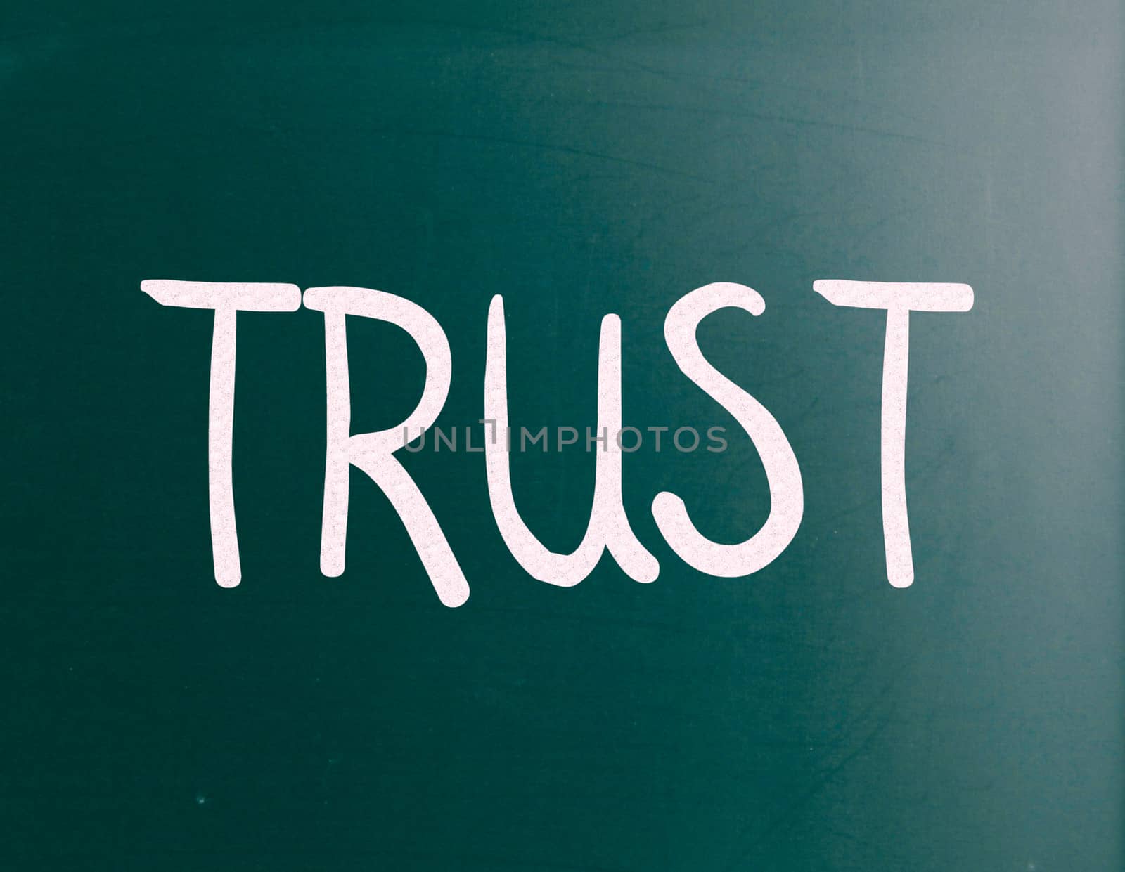 The word "Trust" handwritten with white chalk on a blackboard