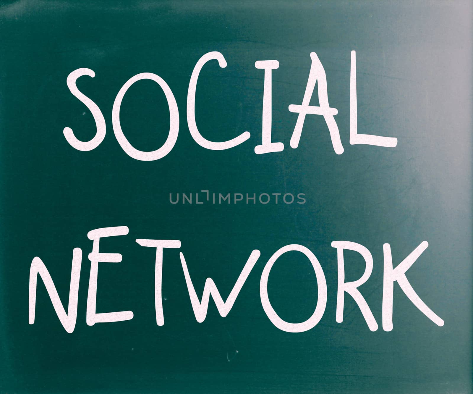 "Social network" handwritten with white chalk on a blackboard by nenov