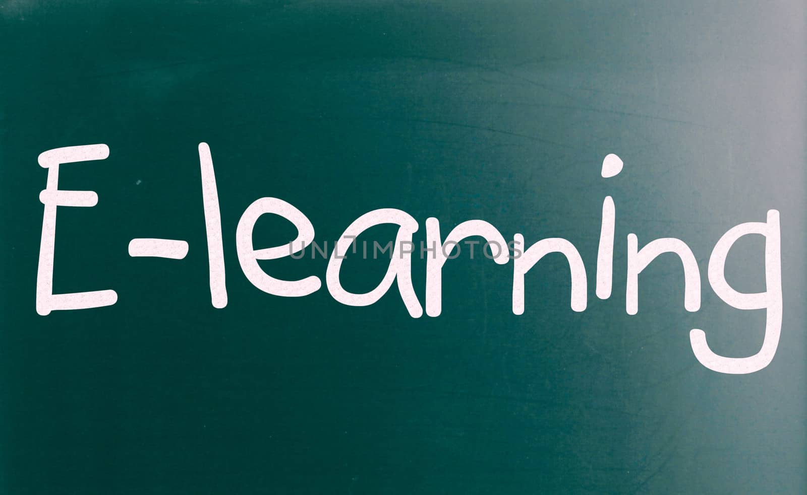 The word "E-learning" handwritten with white chalk on a blackboard