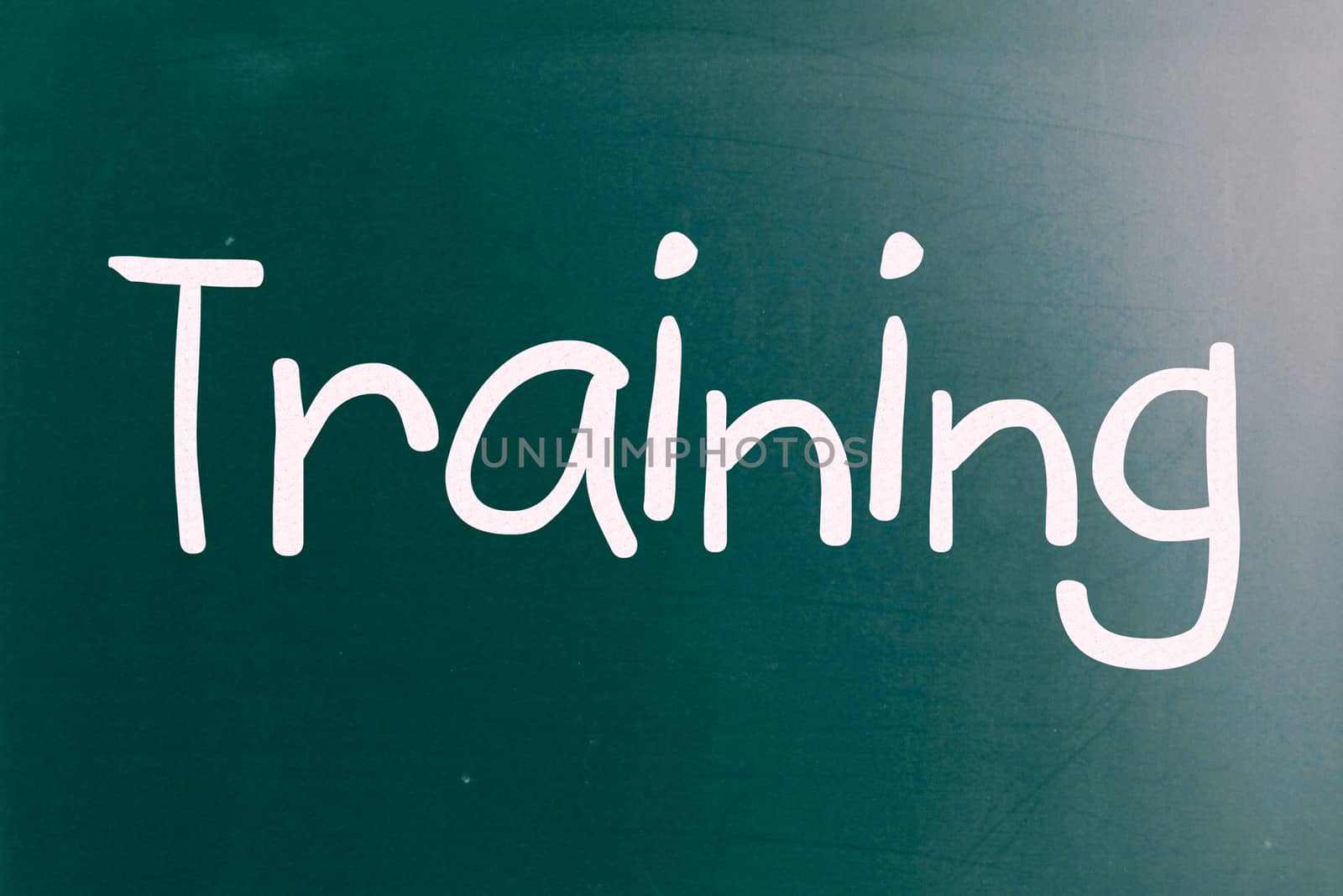 The word "Training" handwritten with white chalk on a blackboard