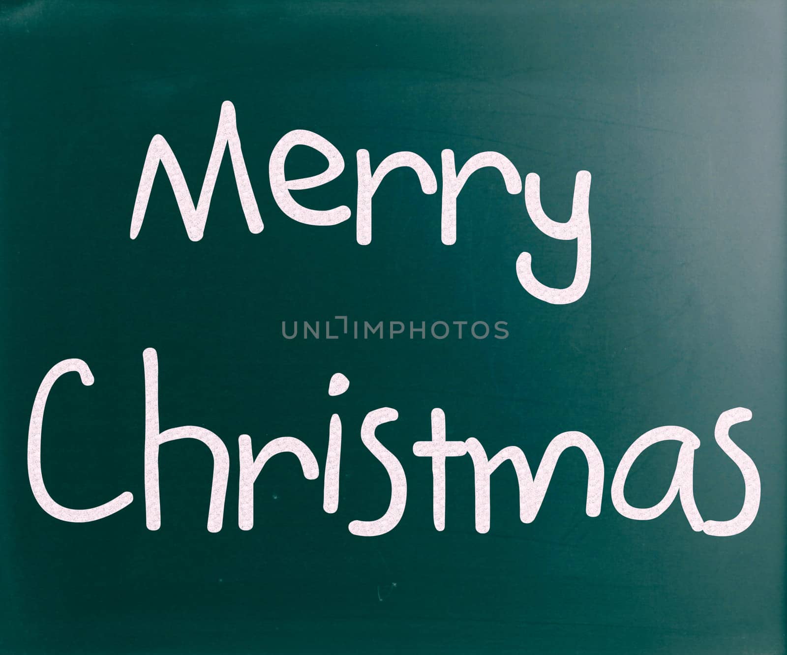 "Merry Christmas" handwritten with white chalk on a blackboard
