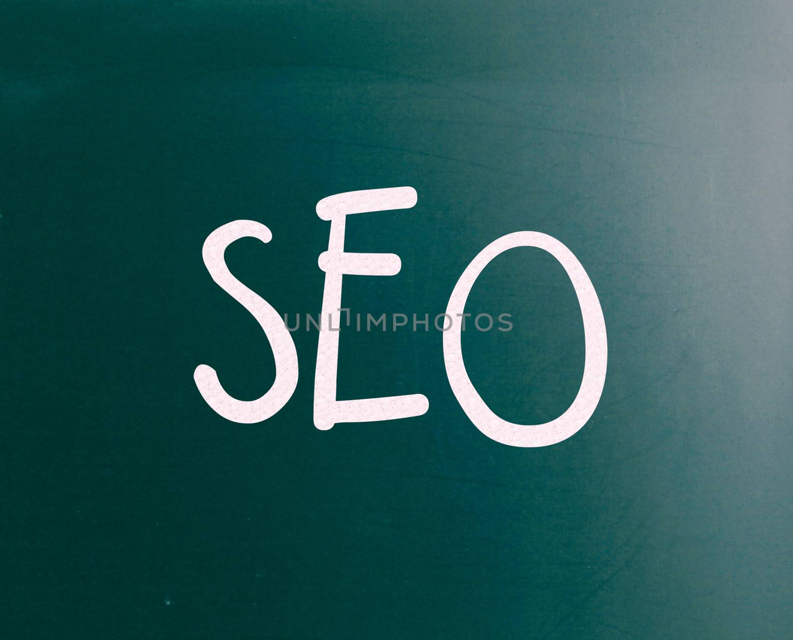 The word "SEO" handwritten with white chalk on a blackboard