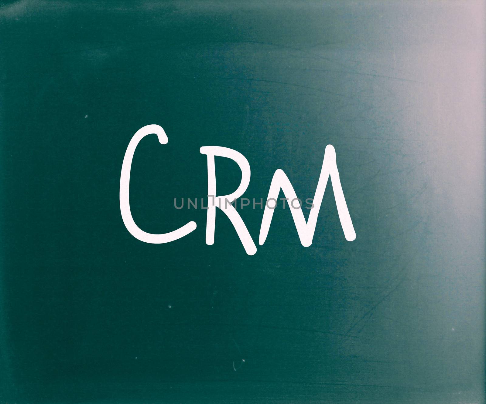 The word "CRM" handwritten with white chalk on a blackboard