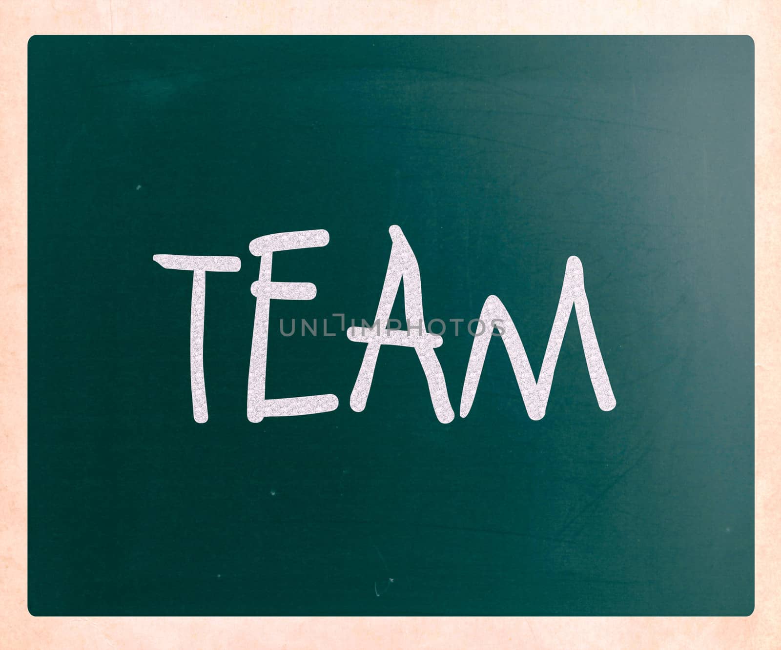 The word "TEAM" handwritten with white chalk on a blackboard