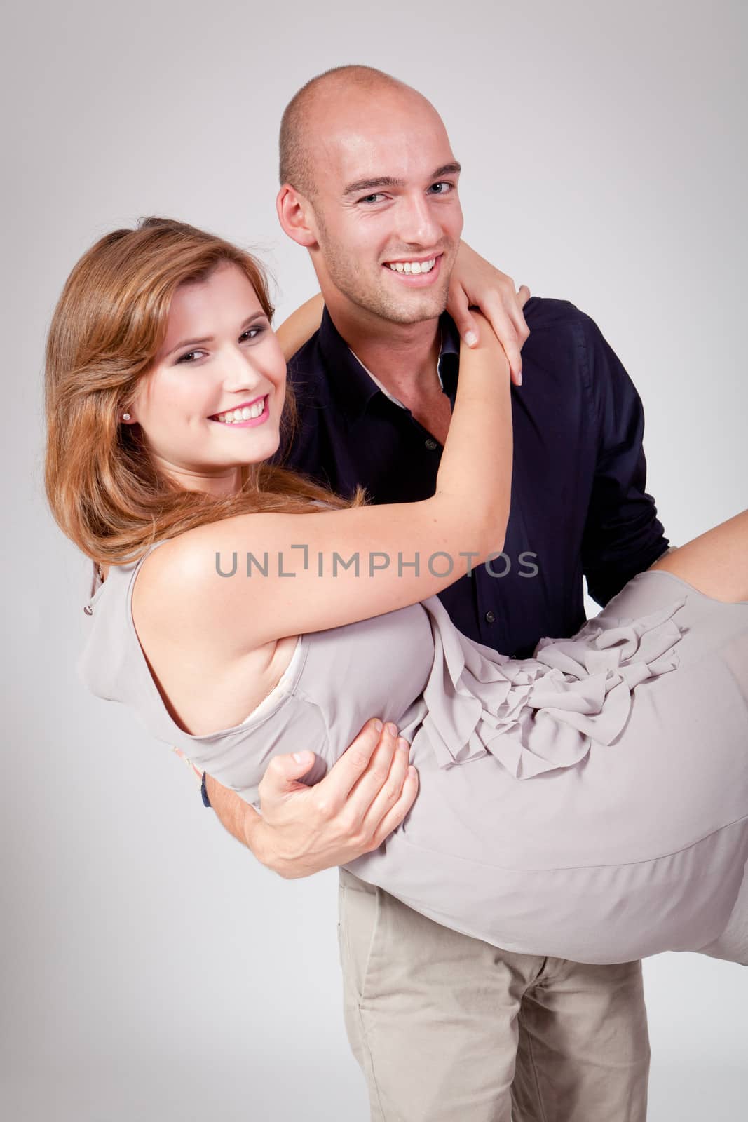 young attractive couple in love embracing portrait on grey backgound 