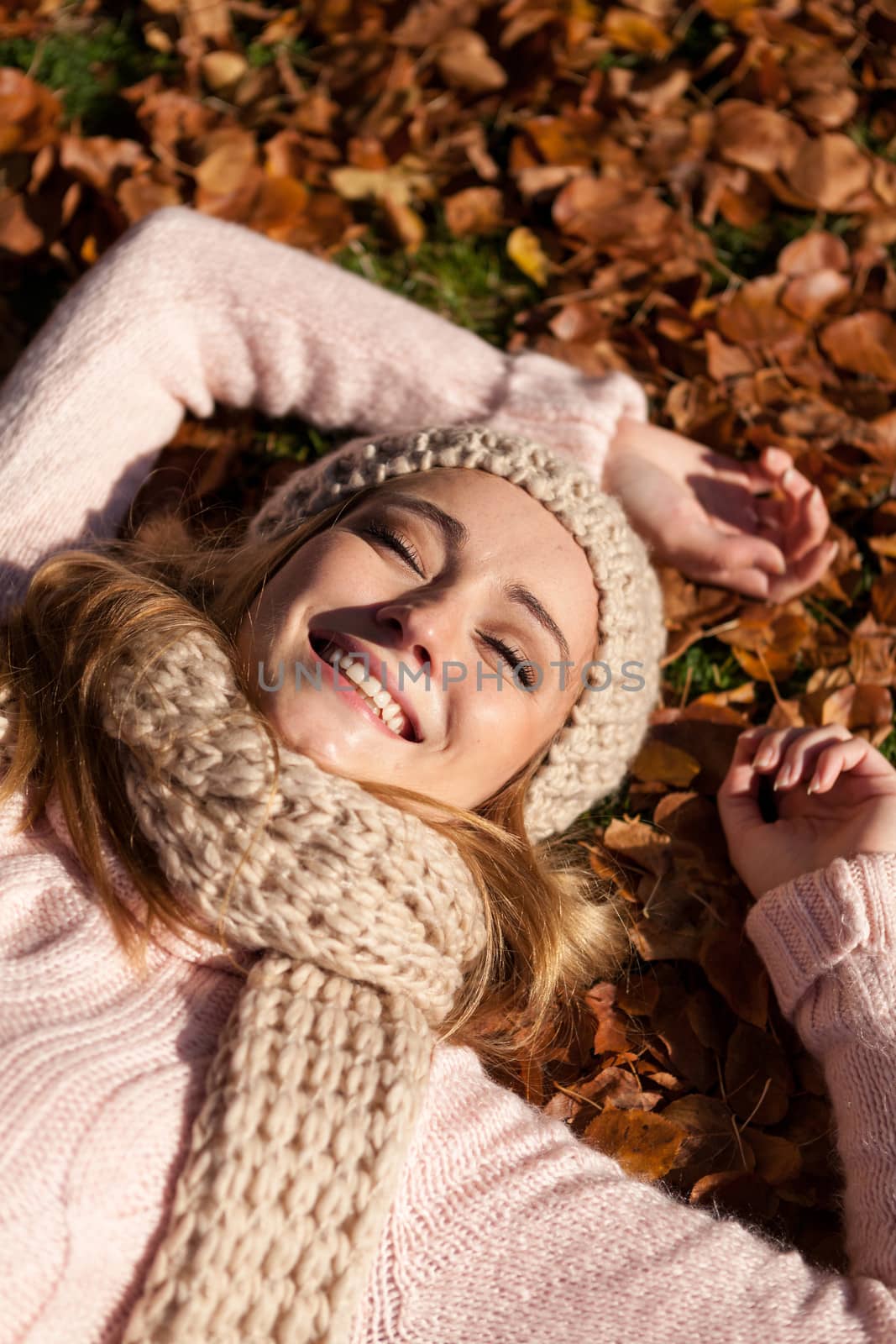 young smiling woman with hat and scarf outdoor in autumn nature background