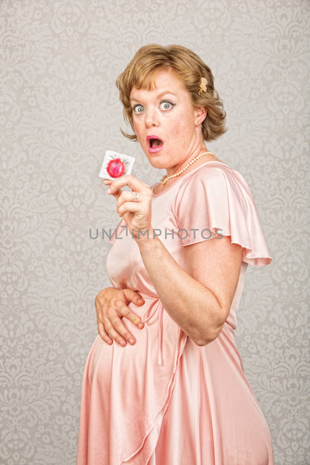 One surprised pregnant female holding a contraceptive
