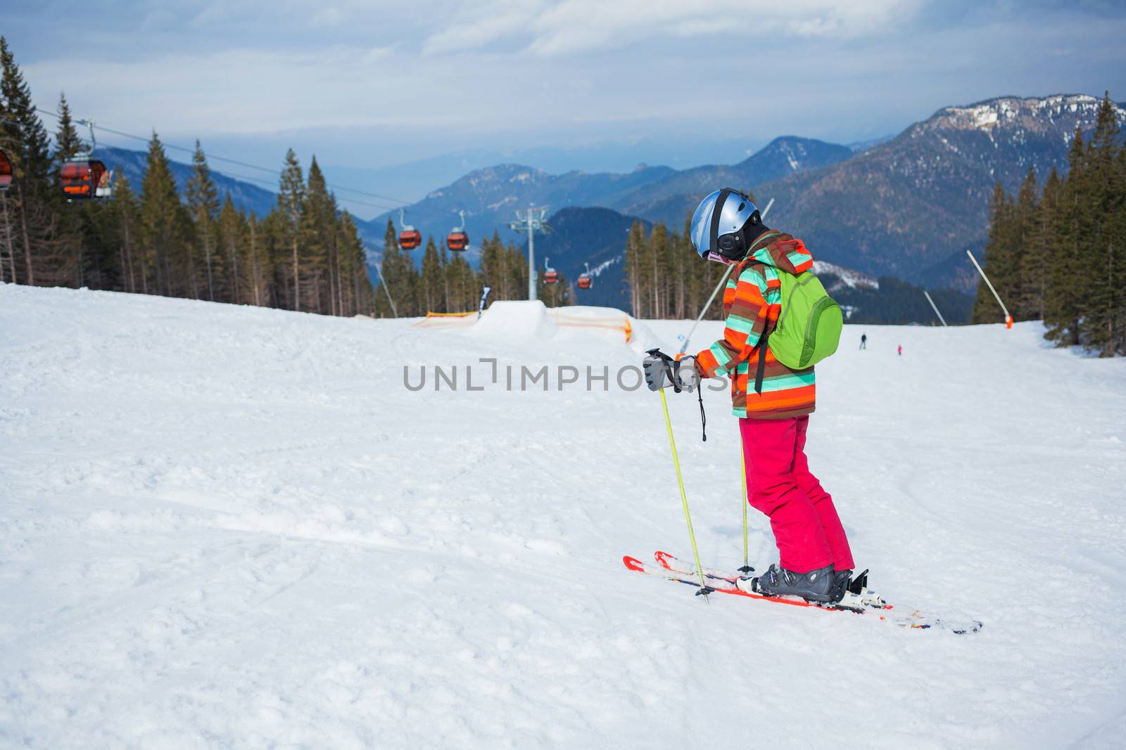 Girl on skis in soft snow on a sunny day in the mountains