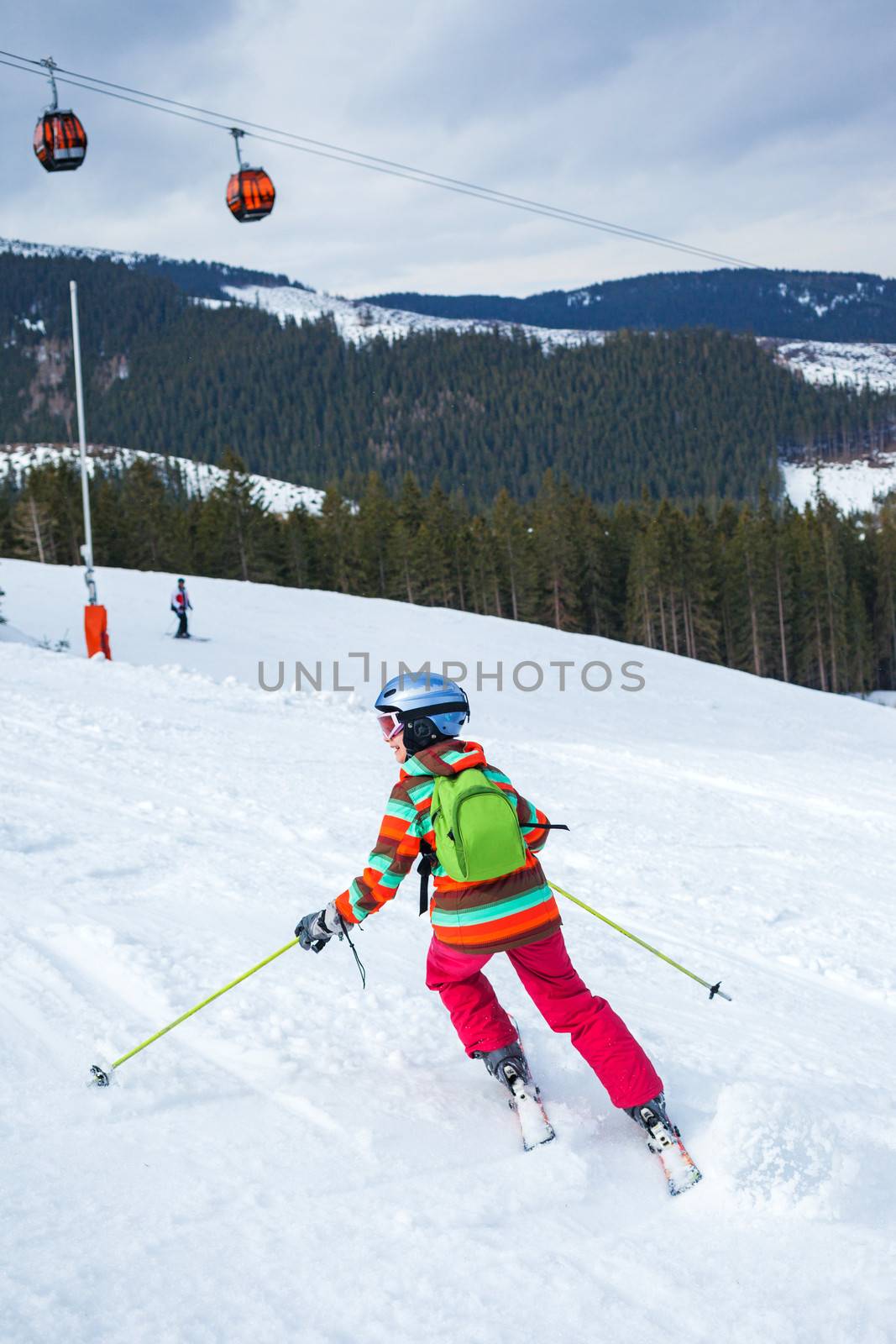 Girl on skis in soft snow on a sunny day in the mountains