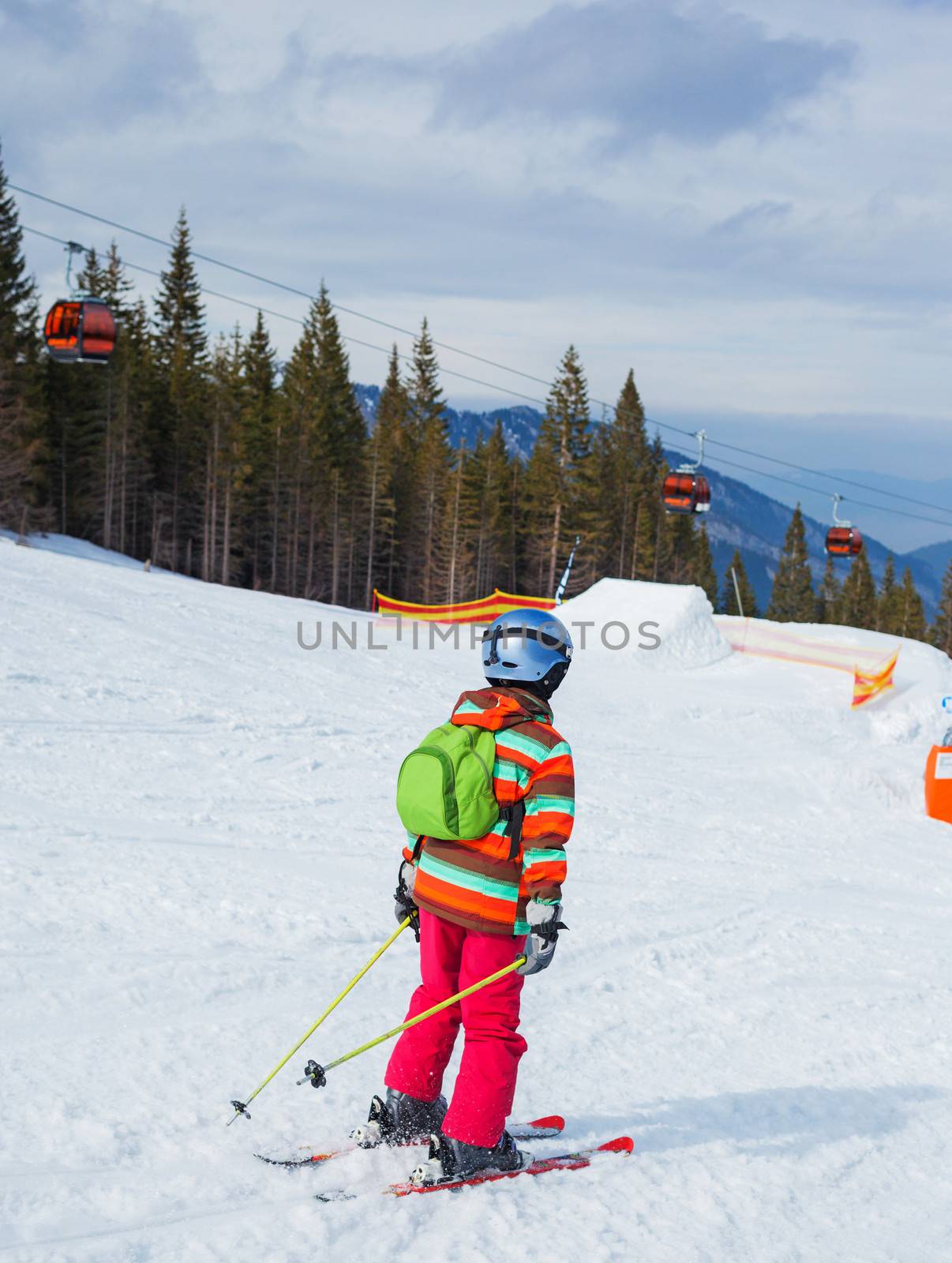 Girl on skis in soft snow on a sunny day in the mountains