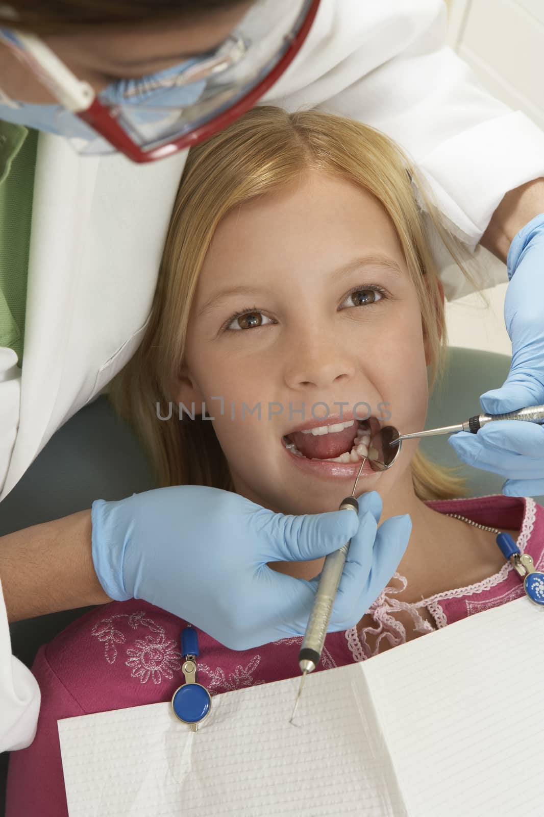 Teenage girl being examined by a female dentist at clinic by moodboard
