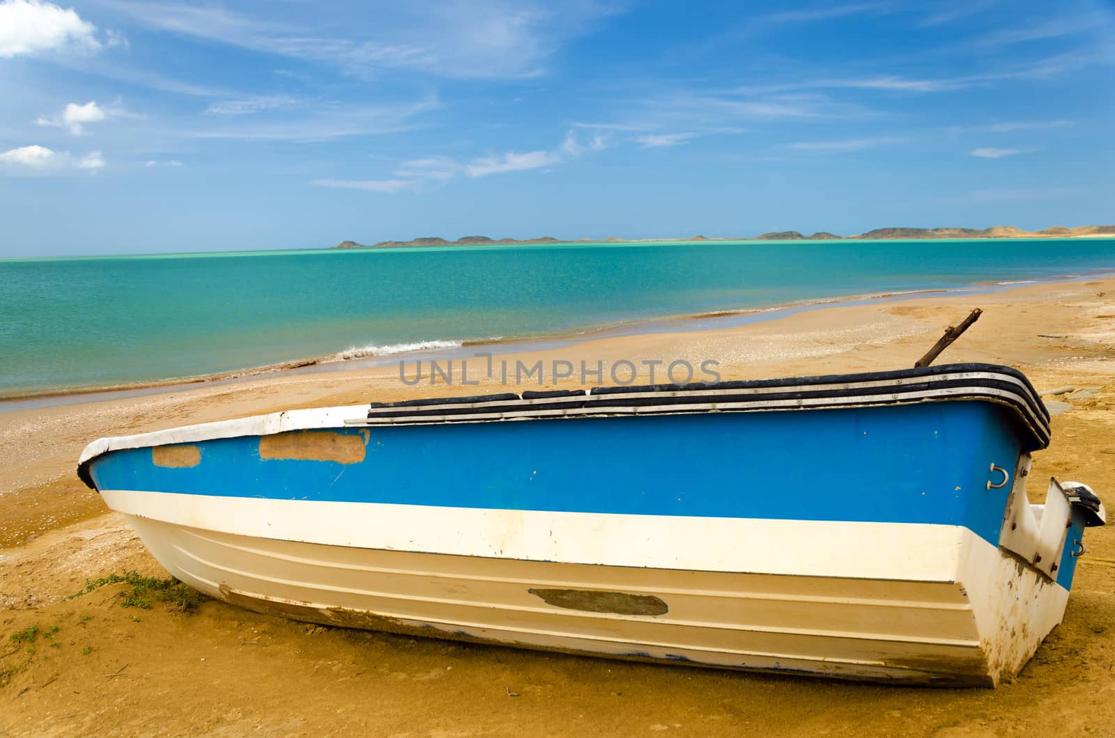 Blue and white boat on a Caribbean beach in La Guajira, Colombia