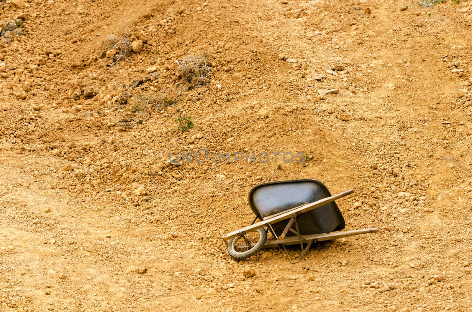 Black wheelbarrow in a dry barren setting