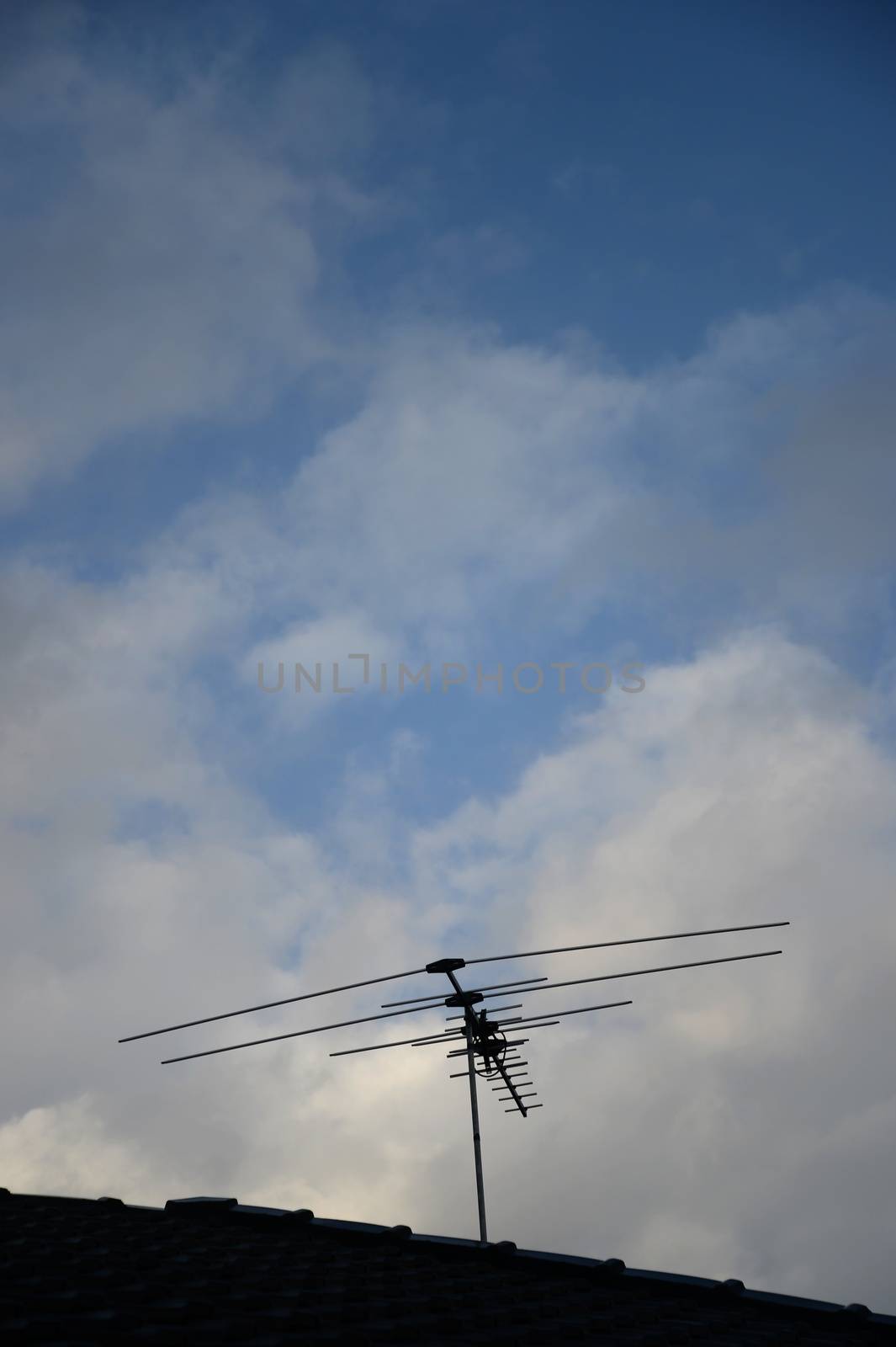 A TV antenna on a tiled roof