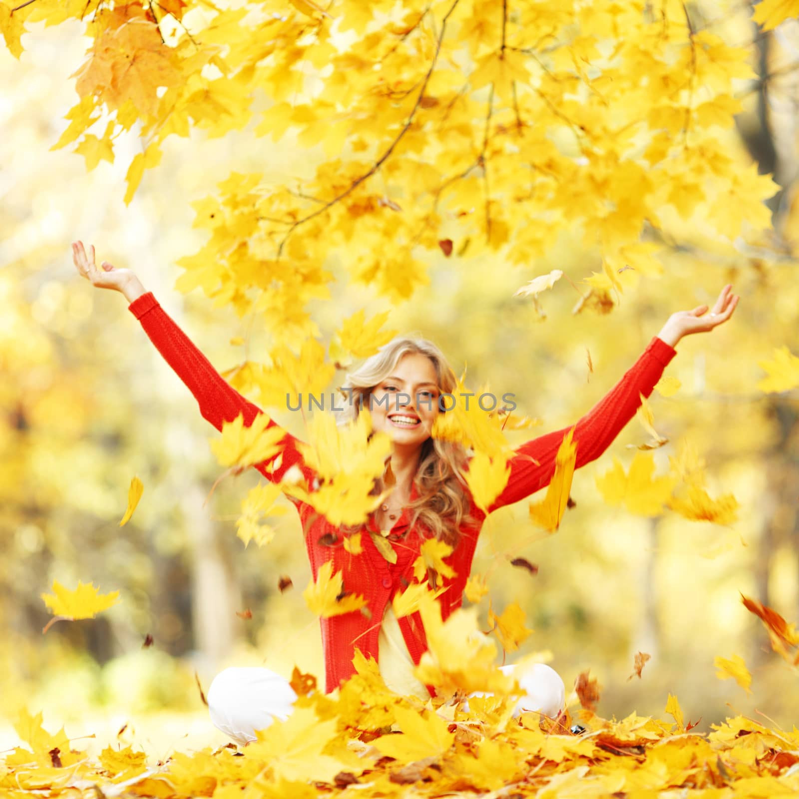 Happy woman in autumn park drop up leaves