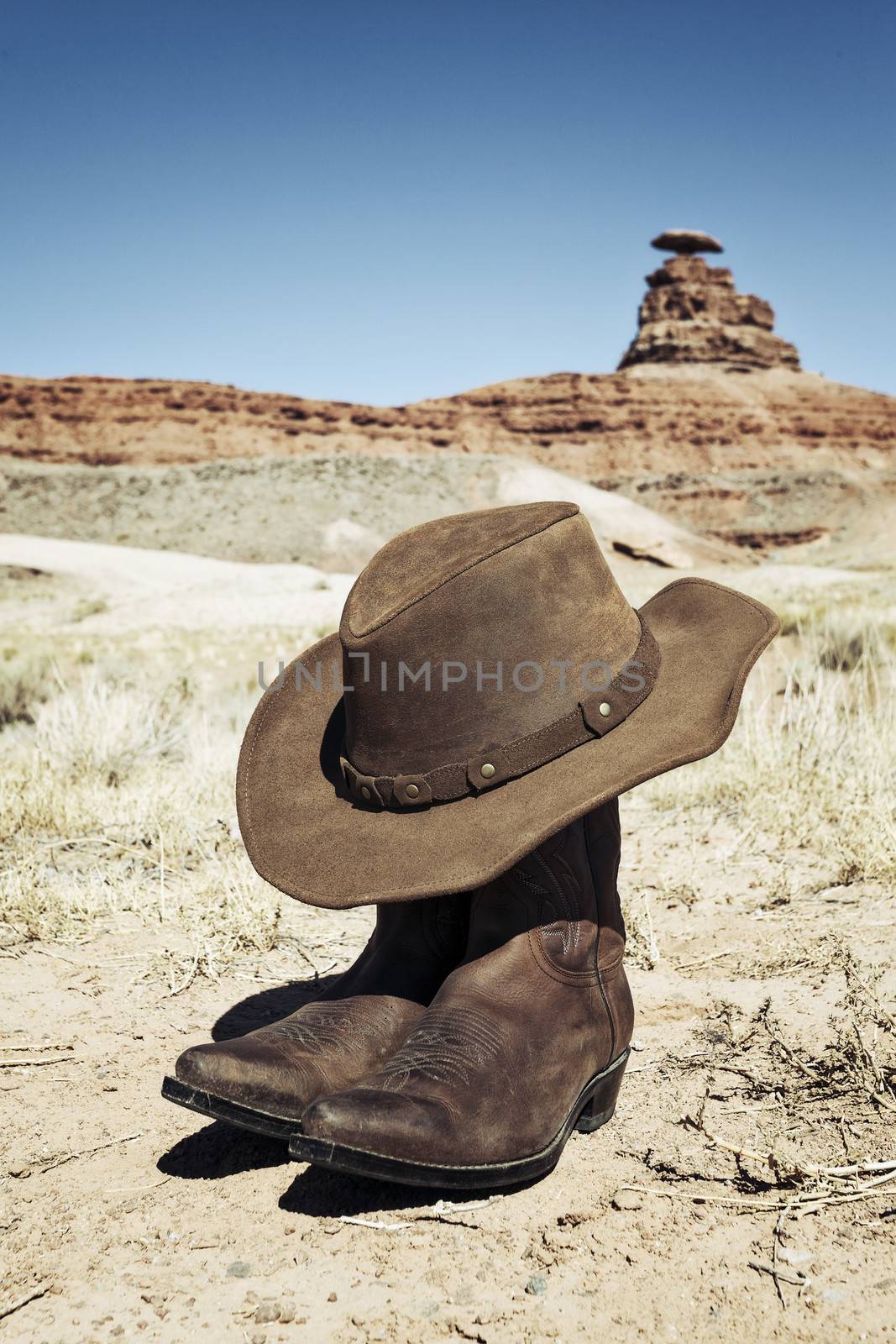 Boots and hat in front of Mexican Hat, USA