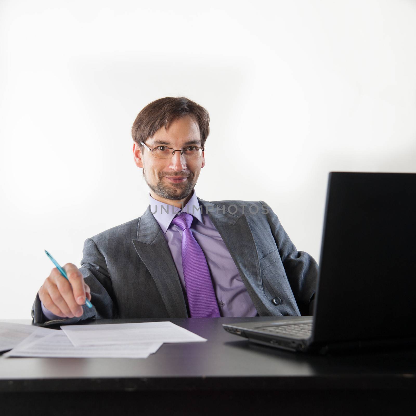 businessman at his desk with a laptop and papers