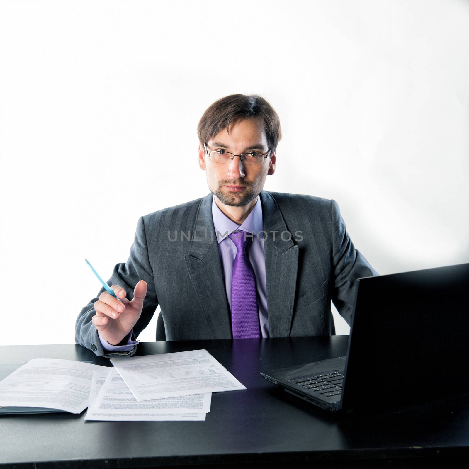 businessman at his desk with a laptop and papers