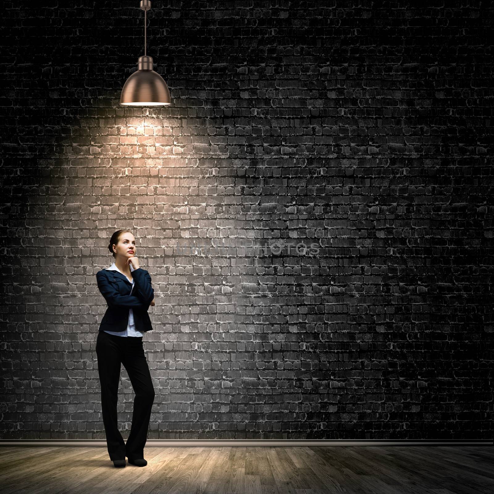 Image of young businesswoman standing under spot of light