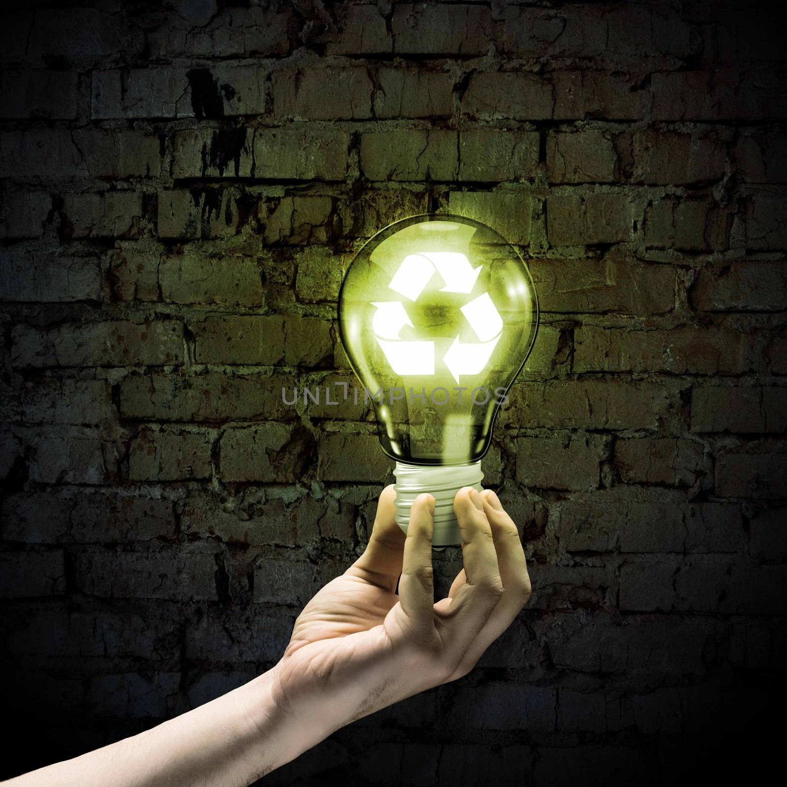 Image of human hand holding bulb with recycle symbol inside