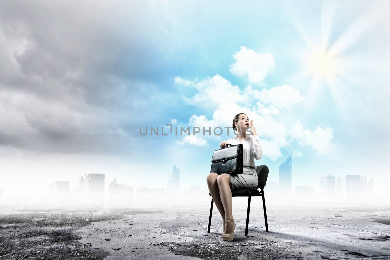 Image of young businesswoman sitting in chair holding suitcase