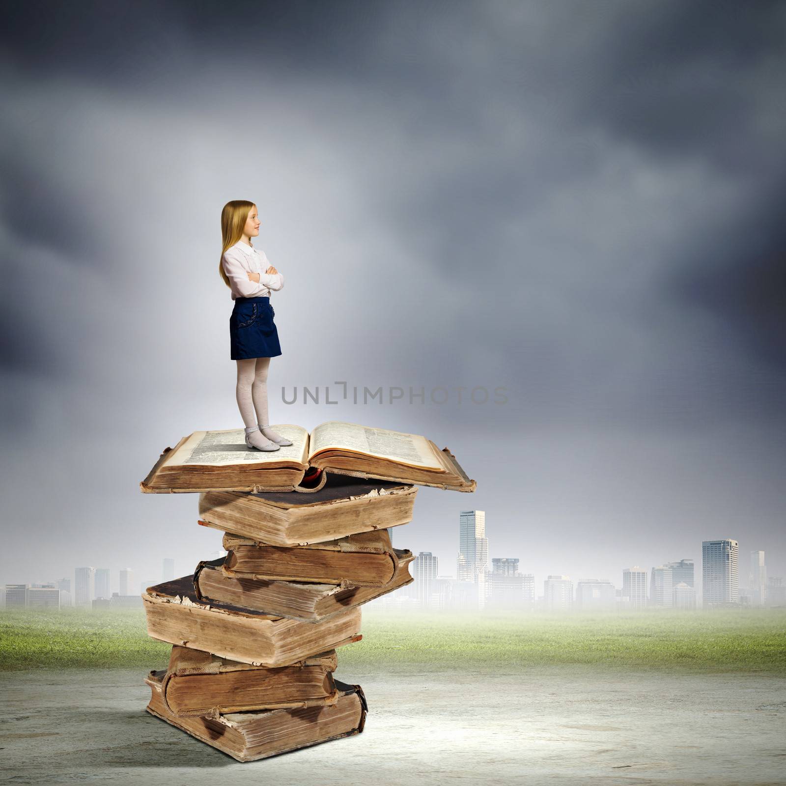 Image of cute school girl standing on pile of books