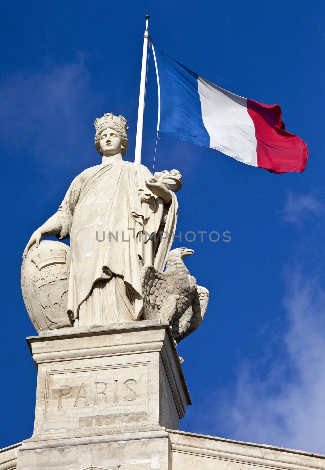 Statue and French flag above the main entrance of Gare du Nord Station in Paris.