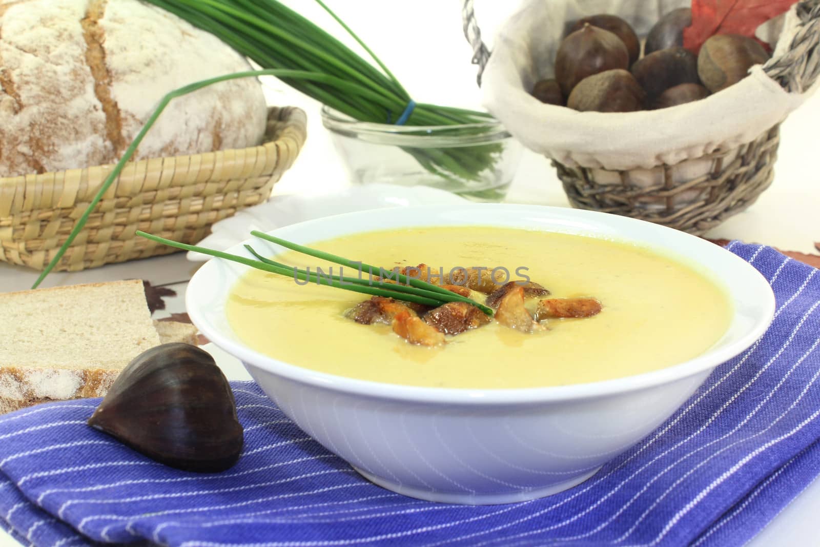 a bowl of sweet chestnut soup with roasted chestnuts and chives