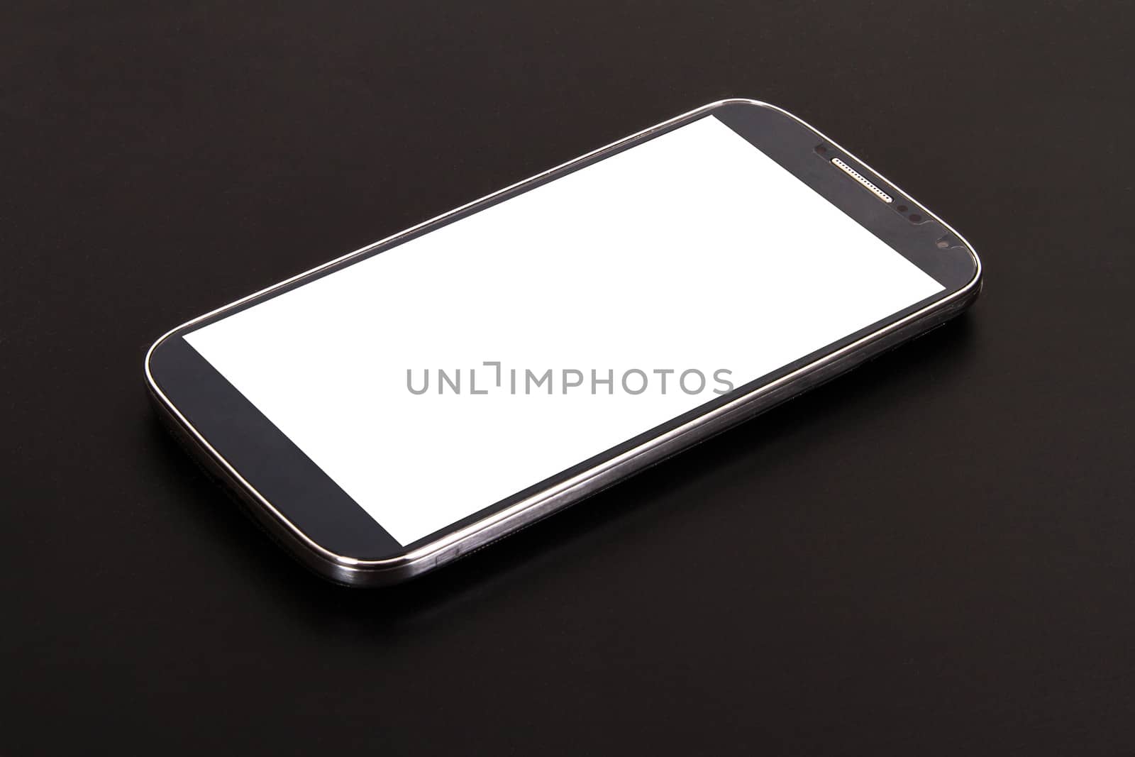Smart phone with blank, white screen, side view on wooden table.
