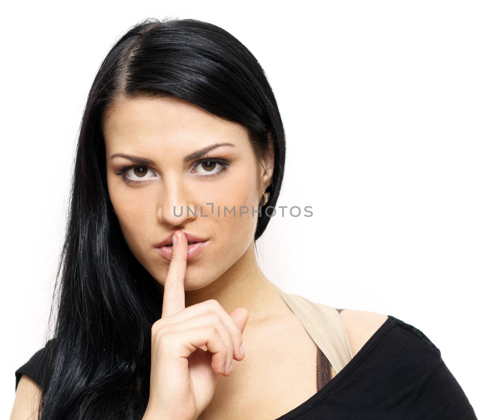 beautiful brunette with a finger on her lips showing to keep silence