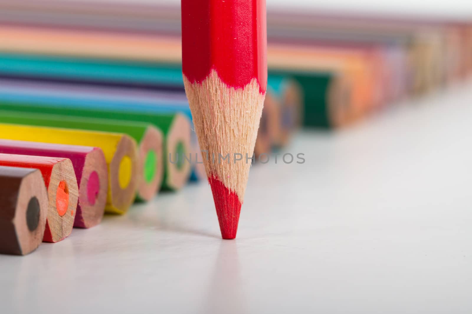 Colorful pencils, focused on red pencil, isolated on white background.