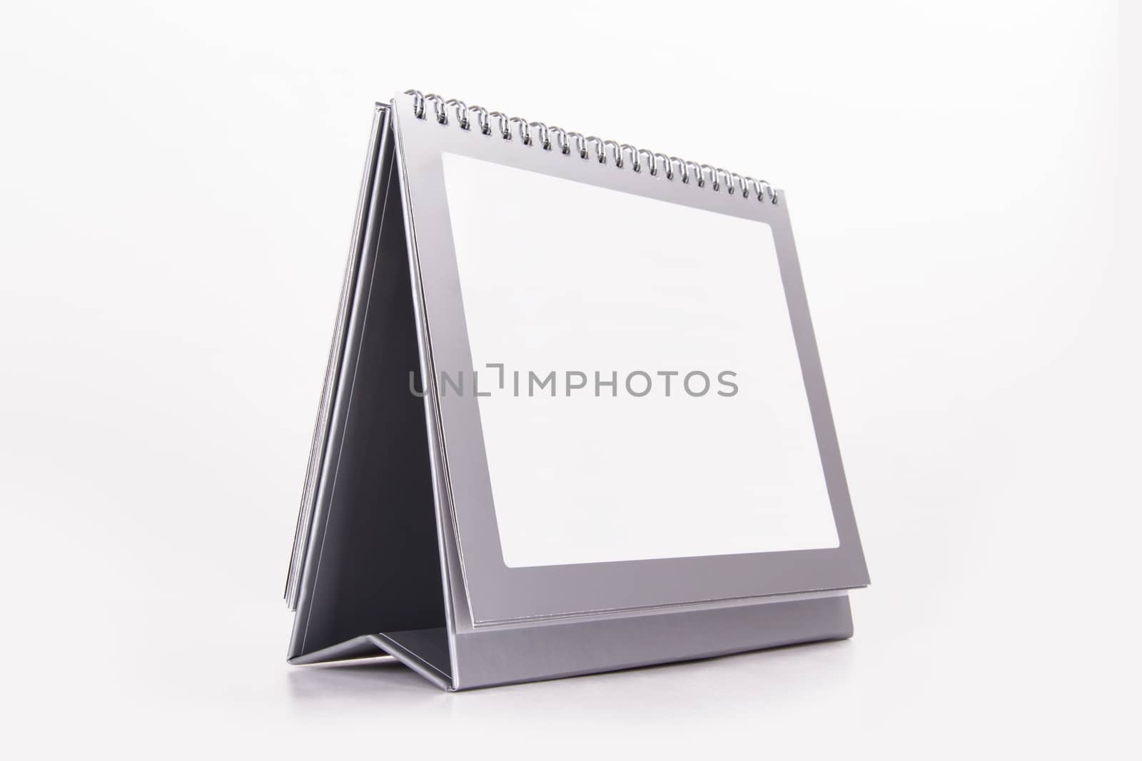 Blank standing desk calendar on perspective, isolated on white background.