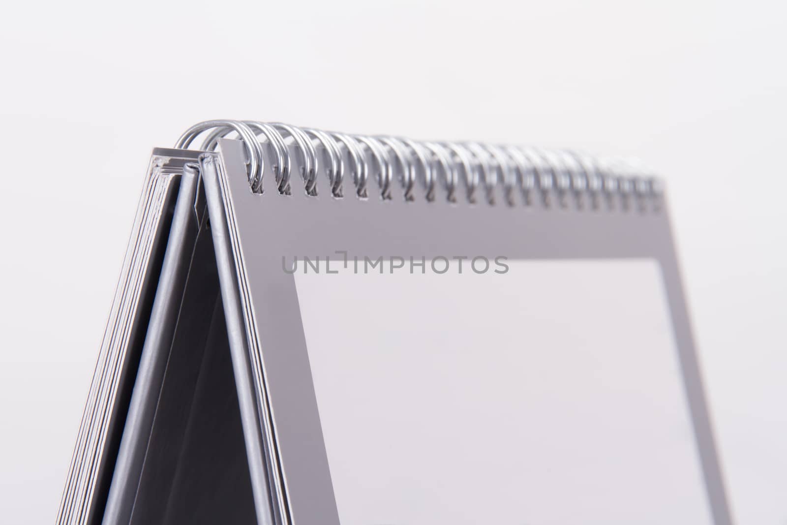 Close up view of blank desk calendar with gray frame, isolated on white background.