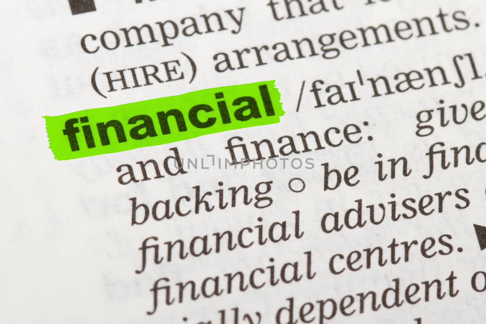 Financial word highlighted with green marker on dictionary page.