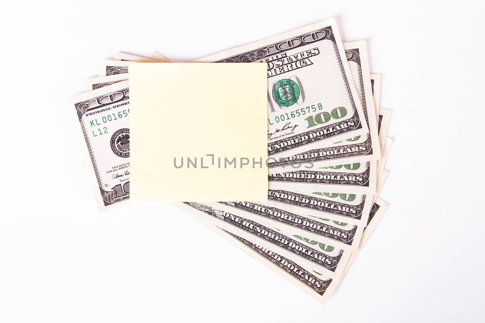 One hundred dollar bills with yellow, blank, empty sticky post it note for your message, isolated on white background.