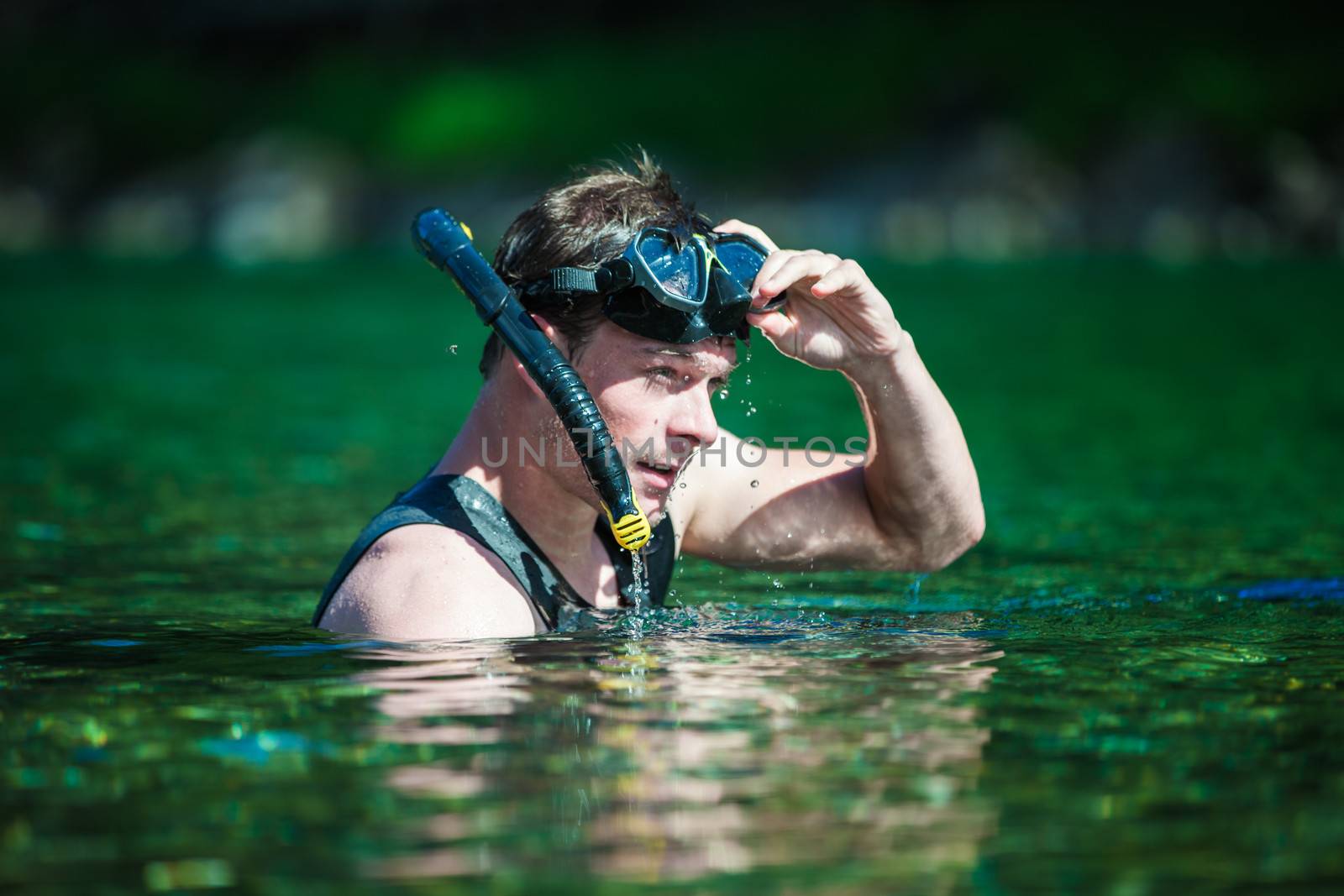 Young Adult Snorkeling in a river with Goggles and Scuba.